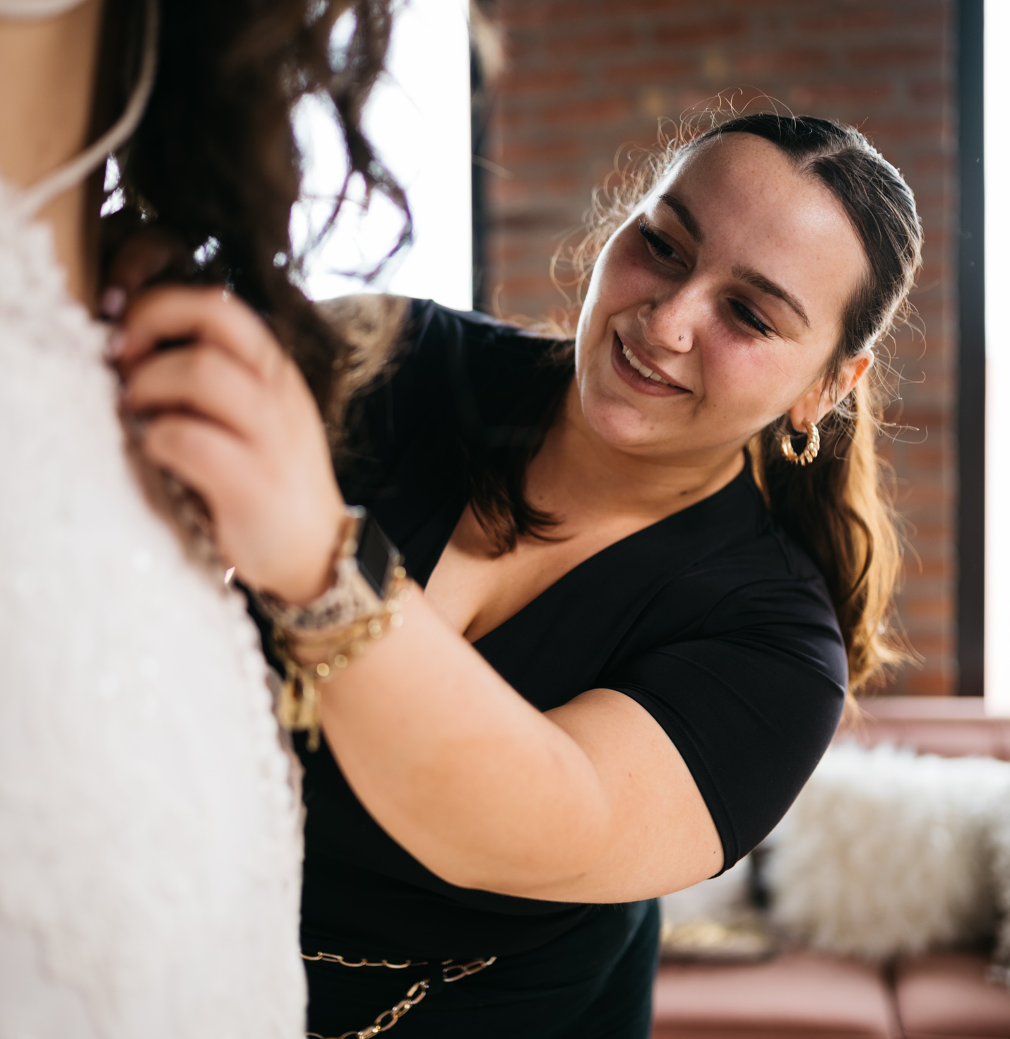 A store assistant helping with a dress fitting.