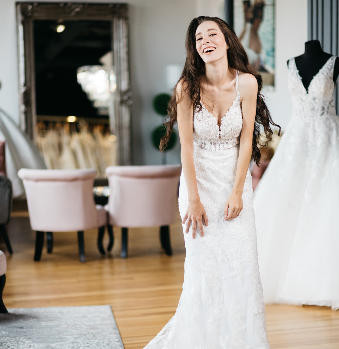 A bride trying on a dress and laughing.