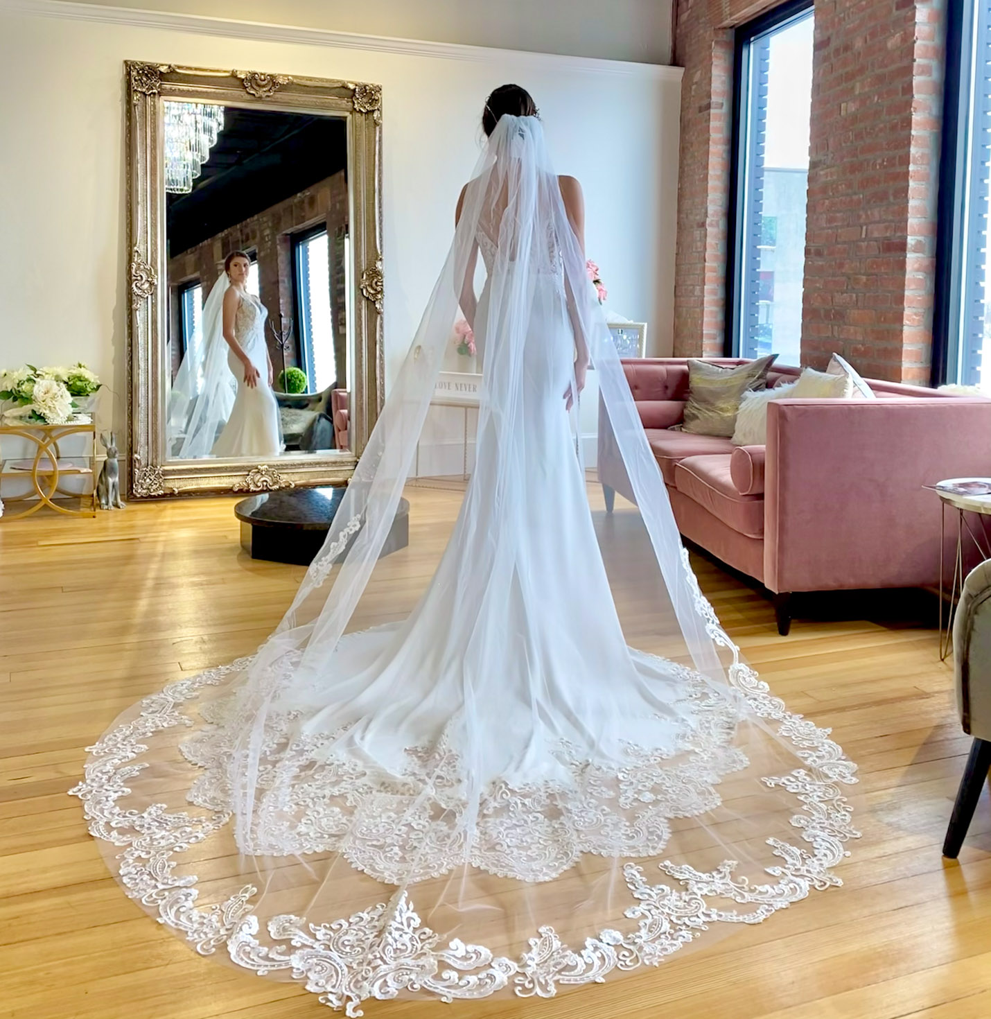 A bride looking in a mirror wearing a veil.