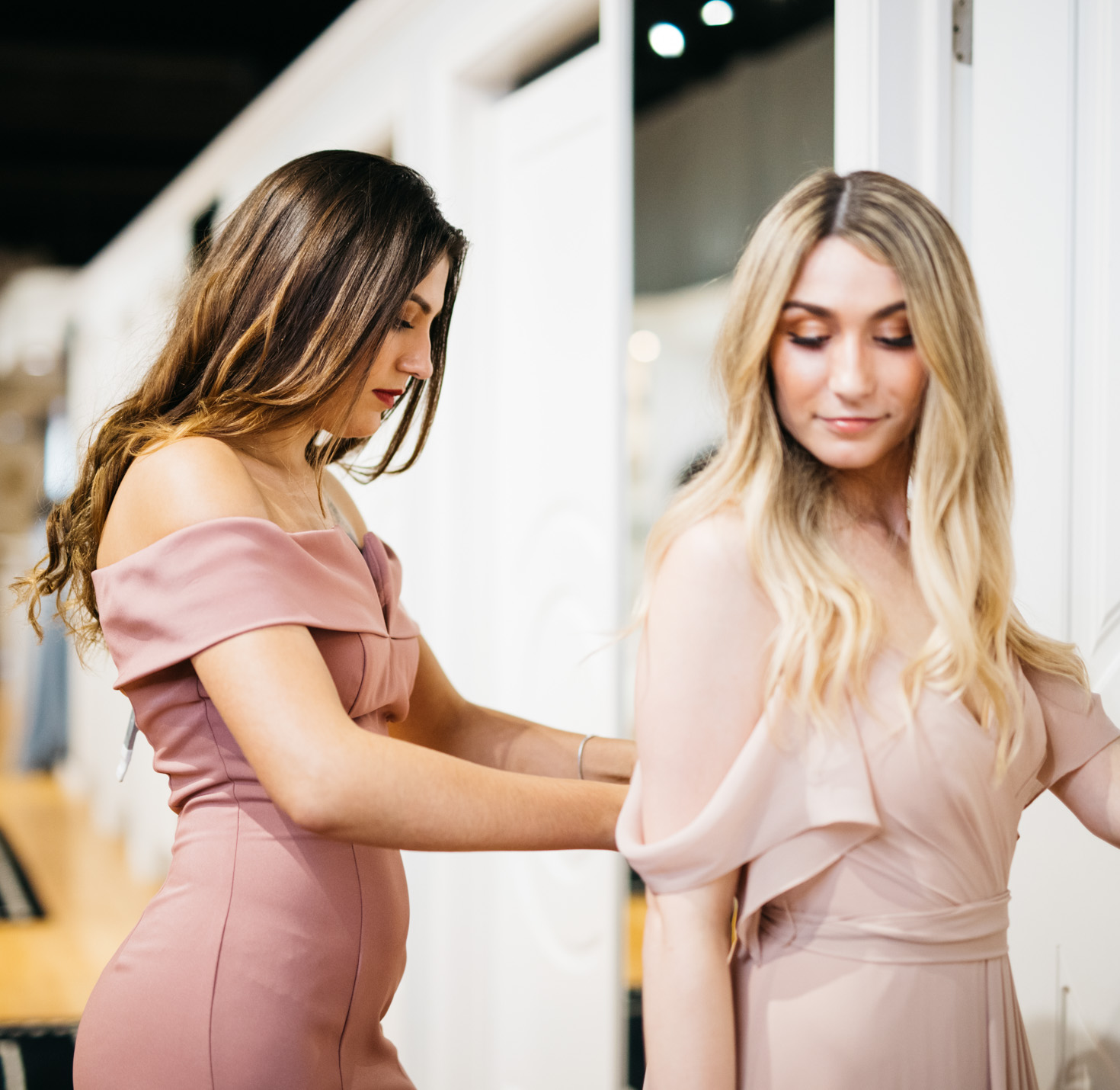 Bridesmaids trying on dresses.