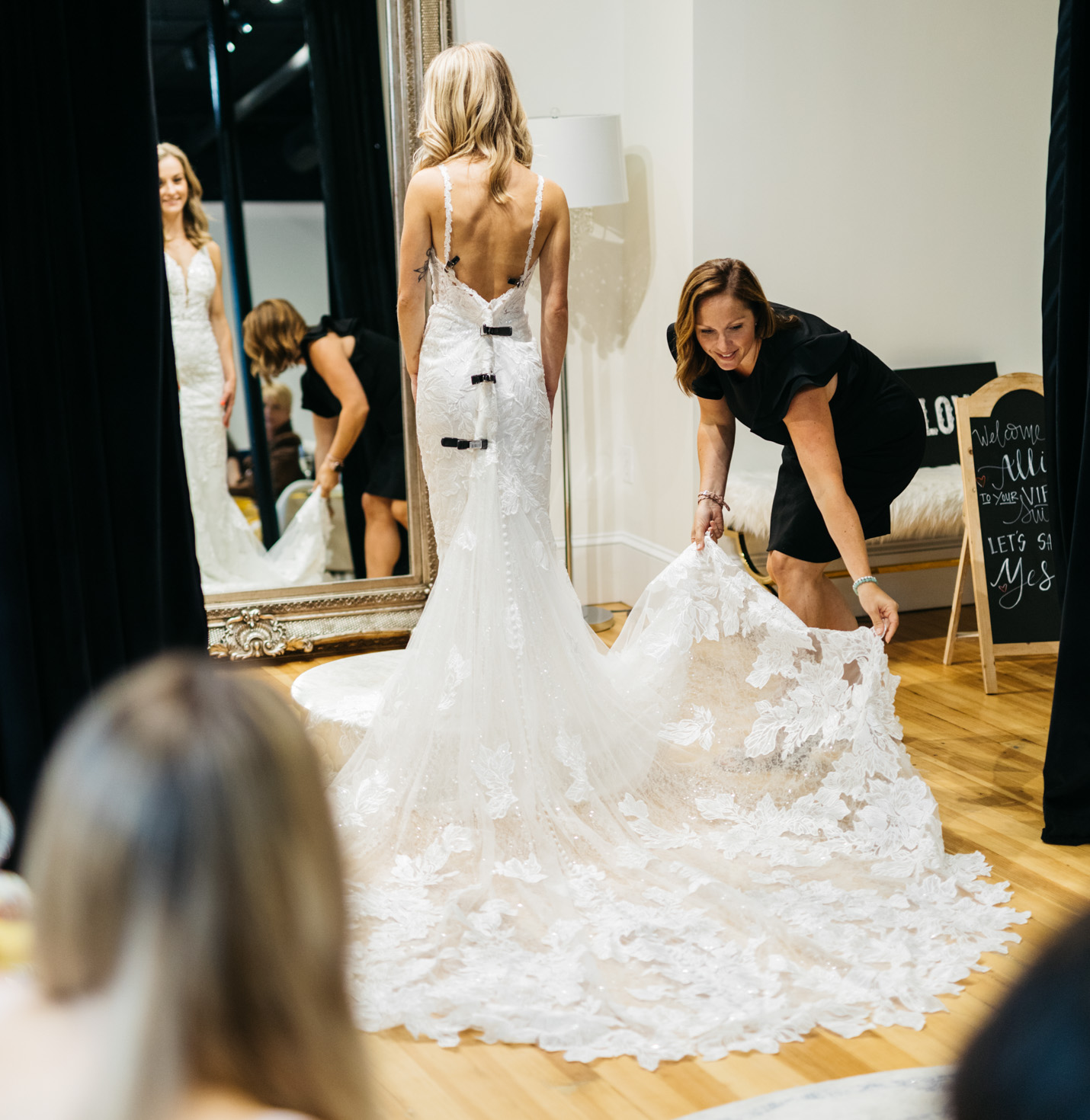A bride trying on a dress with a store employee.
